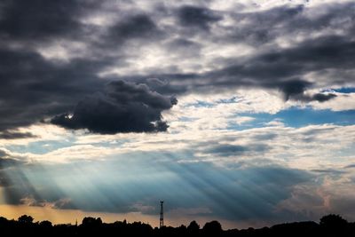 Silhouette of trees against cloudy sky