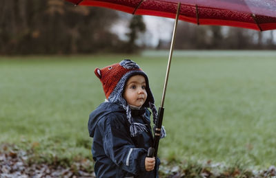 Cute boy under umbrella in park