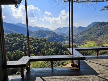 Empty benches and table against mountains