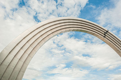 Low angle view of arch bridge against cloudy sky