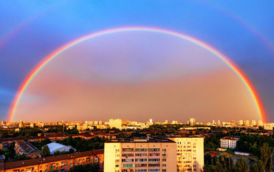 Scenic view of rainbow over buildings against sky