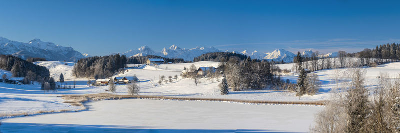 Scenic view of snowcapped mountains against blue sky