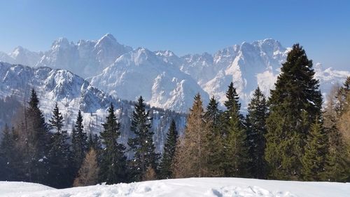 Scenic view of snow covered mountain against blue sky