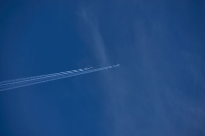 Low angle view of vapor trail in blue sky