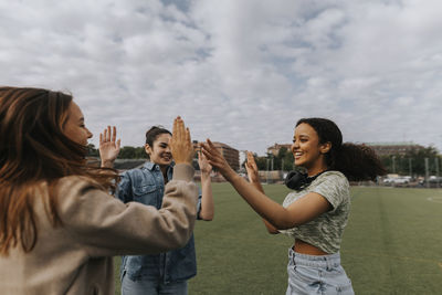 Happy teenage girls giving each other high fives