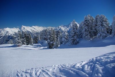 Scenic view of snowcapped mountains against blue sky