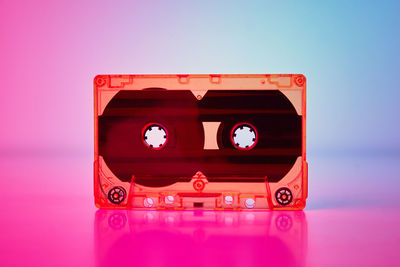 Close-up of toy car on table against pink background