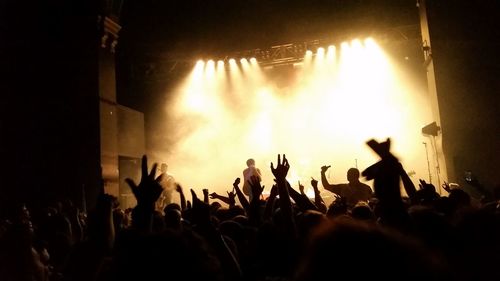 Close-up of hands photographing at music concert