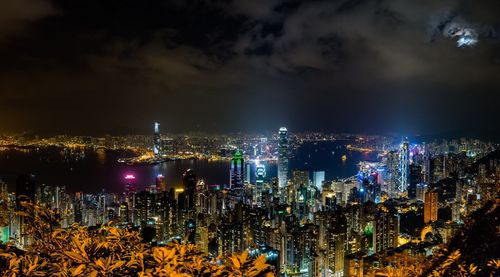 Illuminated cityscape against sky at night