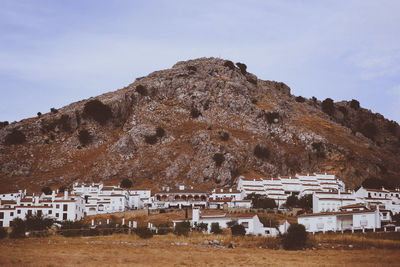 Built structure on rocky mountain against sky