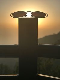 Close-up of silhouette lamp against sky