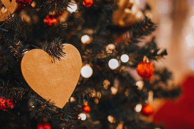 Festive toy in the shape of a heart hanging on the christmas tree. winter holidays concept.