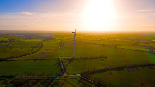 Scenic view of agricultural field against sky during sunset