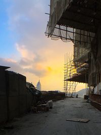 Empty road along buildings at sunset