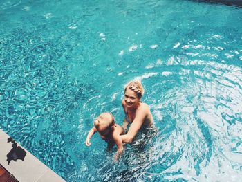 High angle view of mother with daughter in swimming pool