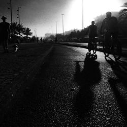 Rear view of people walking on road