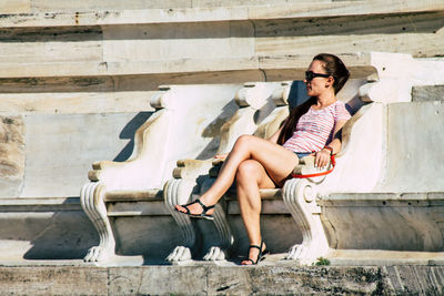 Full length of woman sitting outdoors