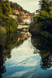 Scenic view of lake by buildings against sky