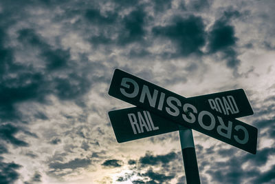 Low angle view of road sign against sky