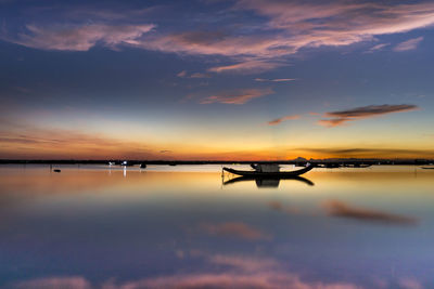 Scenic view of sea against dramatic sky during sunset