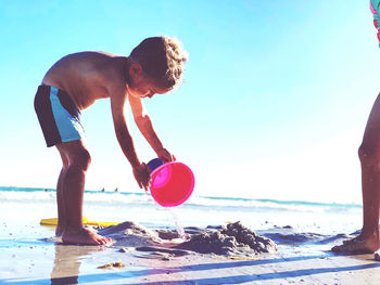 Rear view of boy playing in sea