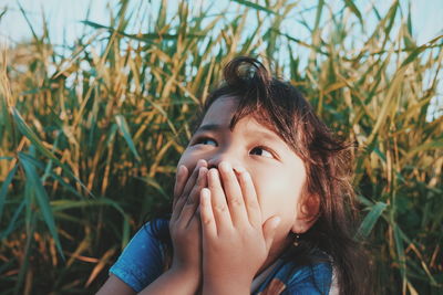 Close-up of girl with hands on mouth