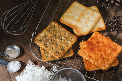 Square dry crackers biscuit on a wooden table. wooden texture dark background. snack dry biscuits