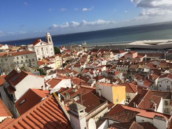 High angle view of townscape by sea against sky