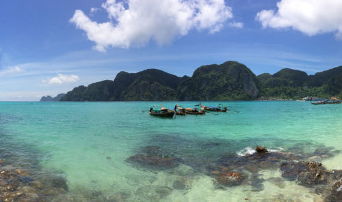 Fishing boats in sea against sky at krabi