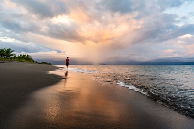 Teen walking on beach with reflection in costa rica