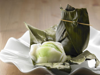 Close-up of food wrapped in banana leaves served in plate on table