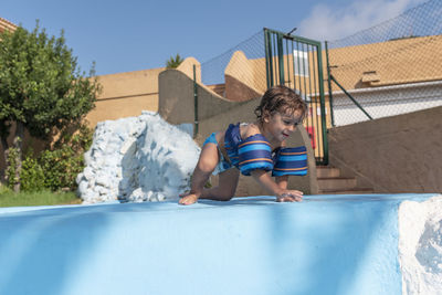 Toddler plays in the pool with children's floats. summer arrives in the northern hemisphere.