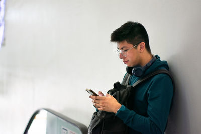 Side view of man standing against wall