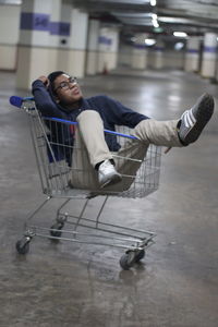 Side view of young man sitting on floor