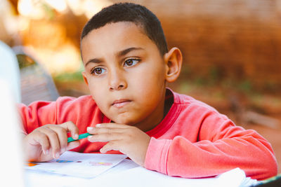 Close-up portrait of boy sitting on table