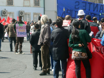 Rear view of people walking on street in city