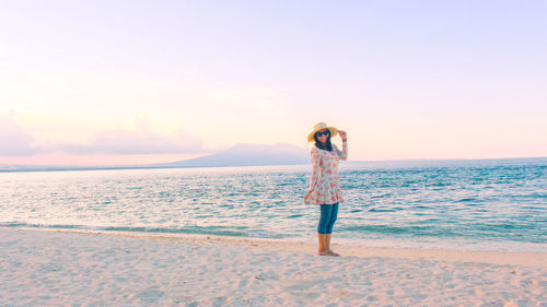 Full length of man standing at beach against sky