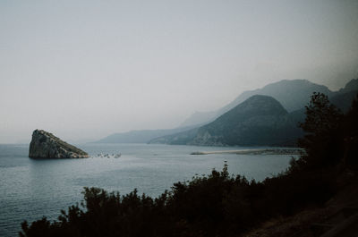 Scenic view of sea and mountains against sky
