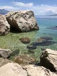 Rock formations in sea against sky