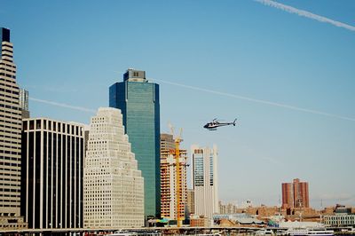 Low angle view of skyscrapers against clear blue sky