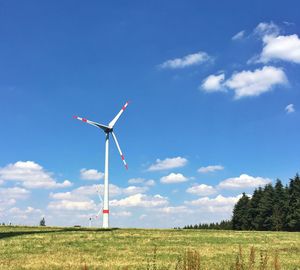 Low angle view of wind turbines on landscape