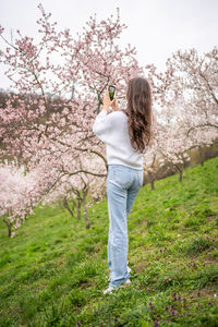 Rear view of woman standing on grassy field