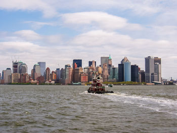 City skyline by river against sky