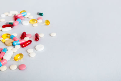 Pills spilling from bottle against white background