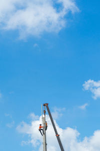 Low angle view of crane against blue sky