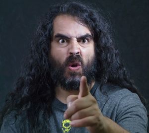 Close-up portrait of angry mid adult man with long hair