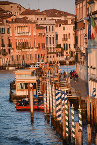 Boats moored in sea against buildings in city