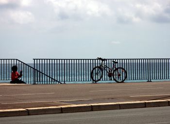 Bicycle on bridge against sky