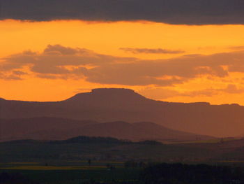 Scenic view of silhouette mountains against sky at sunset