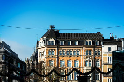 Low angle view of buildings against blue sky